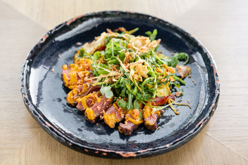 Roast beef, vegetables, carrot and oyster sauce. Sliced grilled beef barbecue Striploin steak and salad with arugula.