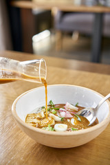 Soup okroshka. Traditional Russian summer cold dish with kvass in bowl on wooden background. Restaurant menu