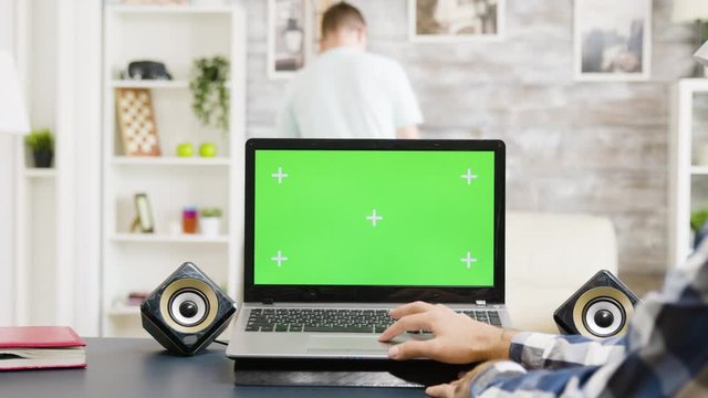 Man scrolling on touchpad on the laptop with green screen