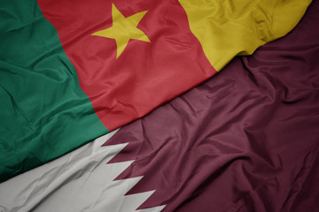 waving colorful flag of qatar and national flag of cameroon.