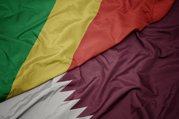waving colorful flag of qatar and national flag of republic of the congo.