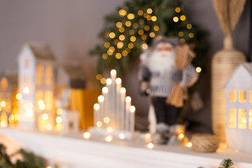 Closeup of Xmas decorations standing in a row on fireplace. Blured photo