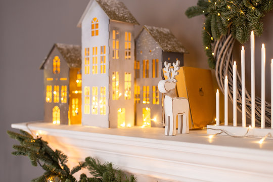 Closeup of paper holiday decorations standing on white fireplace