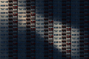Fototapeta na wymiar architectural pattern, facade of a skyscraper with balconies and flower box in the night