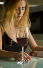 Attractive young woman with glass of wine at home 