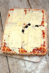 rectangular pizza with cheese on a wooden table