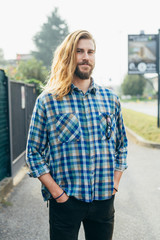 Young beautiful long hair bearded man outdoor posing looking camera