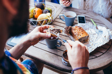 Close up man hand spreading hazelnut spread on a slice of cake