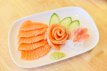 Salmon sashimi menu set Japanese cuisine fresh ingredients on plate - Japanese food raw sashimi salmon fillet with vegetable cucumber and wasabi in the restaurant