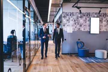 Fototapeta premium Busy multiethnic men office workers walking and talking at office