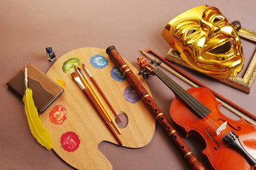 Fototapeta premium Attributes of the arts. Music, painting, literature, theater. Violin, art palette and brushes, fountain pen, notebook, theater mask.