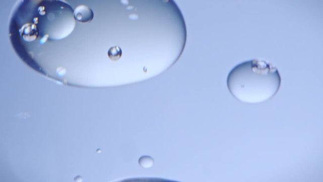 Macro closeup of oil drops floating in water. Slowmotion 240fps