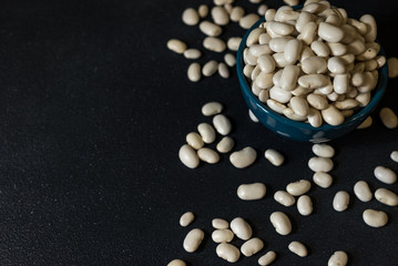 healthy white beans in a dark gray background