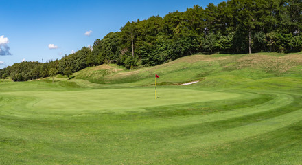 Panorama view of Golf Course with beautiful putting green. Golf course with a rich green turf beautiful scenery.