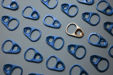 Pattern of ring pull or can pull tab ,one gold pull tab different from the rest in blue ,represent...