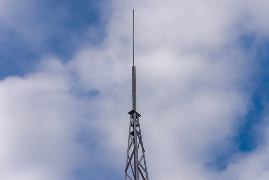 Lightning rod on a blue cloudy sky.