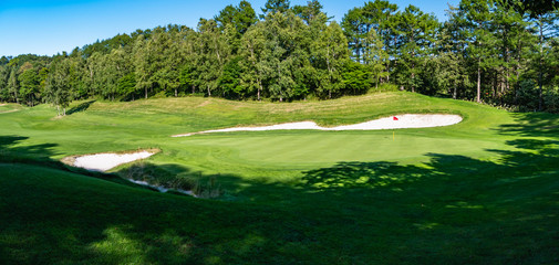 Obraz premium View of Golf Course with beautiful putting green. Golf course with a rich green turf beautiful scenery. 