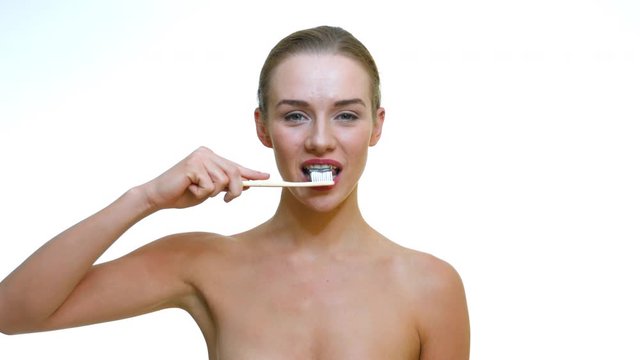 Healthy woman with perfect white smile cleaning her teeth with a bamboo toothbrush and black carbon toothpaste.