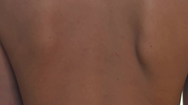 Close up on female backbone over white studio background.
