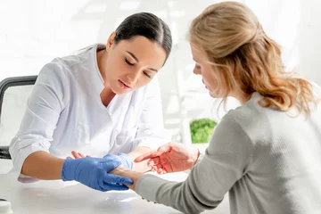 Poster attractive dermatologist in white coat examining skin of patient in clinic © LIGHTFIELD STUDIOS