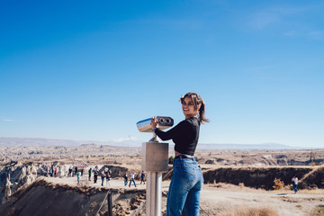 Fototapeta na wymiar Woman exploring desert with binoculars on observation deck
