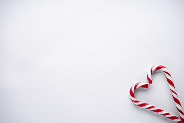 Christmas concept. Christmas candy in the corner in the form of a heart on a white background. Place for text, flat lay.