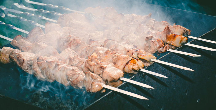 Meat skewer with onion on the skewers on the grill at the stake 