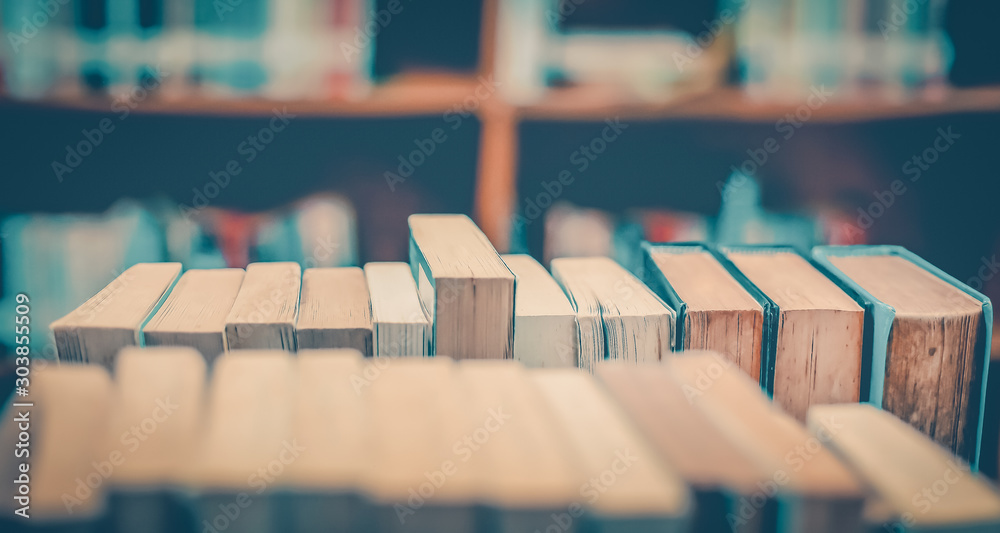 Poster stack of books in the library and blur bookshelf background