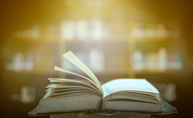 Stack of books in the library and blur bookshelf background