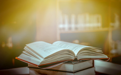 Stack of books in the library and blur bookshelf background