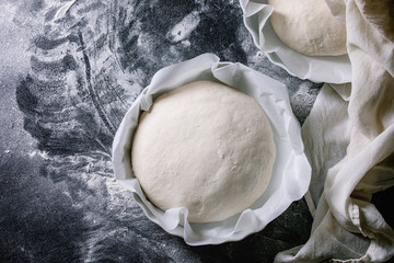 Process of making homemade bread. Fresh dough redy for baking on baked paper over black table with...