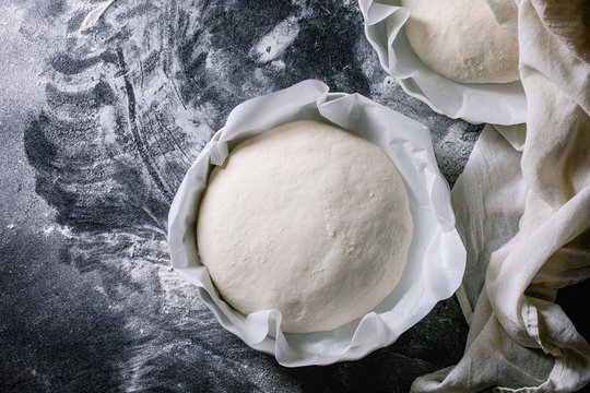 Process of making homemade bread. Fresh dough redy for baking on baked paper over black table with flour. Home bread baking. Photo series. Flat lay, space