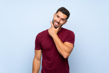 Handsome man over isolated blue background smiling