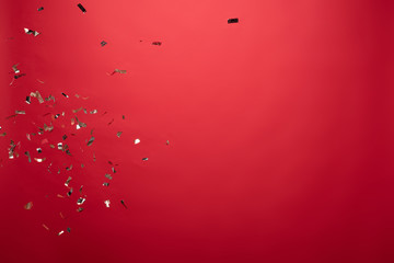 view of golden confetti isolated on red with copy space