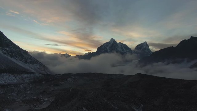Taboche and Cholatse Mountain at Colorful Sunset. Himalaya, Nepal. Aerial View. Drone Flies Backwards