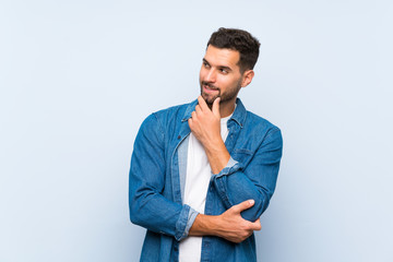 Handsome man over isolated blue background looking to the side