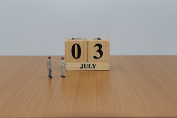 July 3, a calendar photo from the wood The table top consists of a book and pen that is ready to use. White background