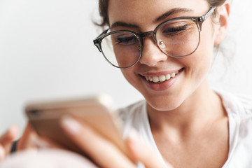 Image closeup of concentrated woman smiling and using cellphone