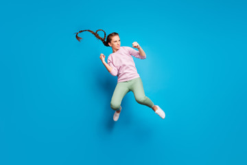 Fototapeta na wymiar Full size profile side photo of serious youngster girl have fighting battle jump kick legs fists enemy want win wear pink pullover white youth sneakers isolated over blue color background