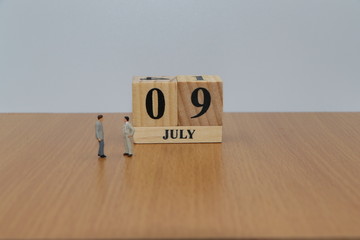 July 9, a calendar photo from the wood The table top consists of a book and pen that is ready to use. White background