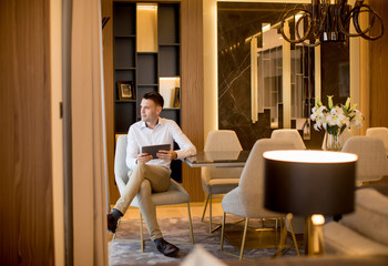 Handsome young man using digital tablet at luxury apartment