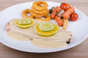Roasted salmon, served with fried breaded onion rings and vegetables