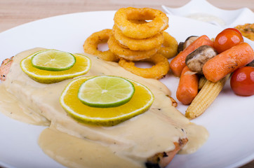 Roasted salmon, served with fried breaded onion rings and vegetables