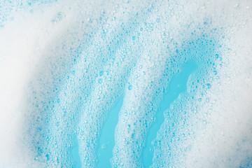 Foam bubble wipe cleaning washing  on blue background on top view texture art abstract