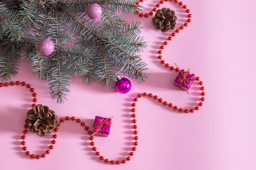 Blue spruce on a pink background with Christmas toys