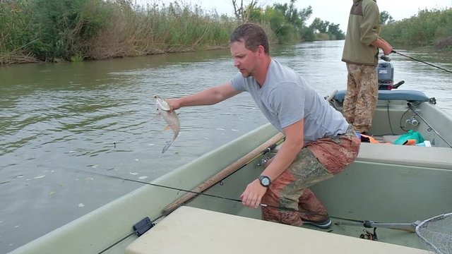 Angler takes the asp fish from the water