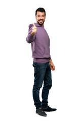 Full-length shot of Handsome man with sweatshirt with thumbs up because something good has happened over isolated white background