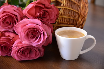 Festive mood. A bouquet of fresh fragrant pink roses for lovers and a white cup of coffee.