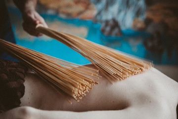  man doing massage with bamboo branches