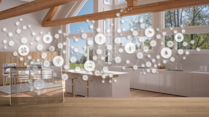 Tablet wireless with smart home app on wooden table, geometric background with connected line and dots showing internet of things system, home automation concept over modern kitchen